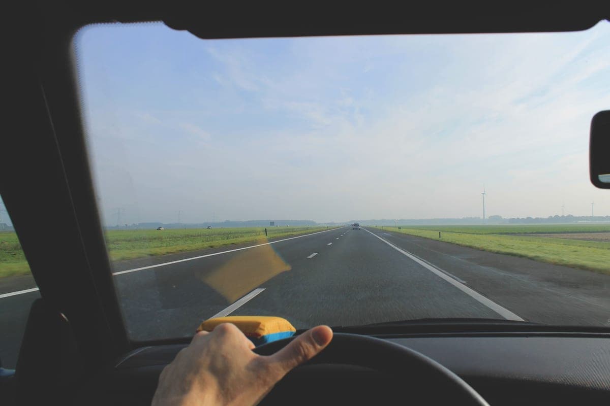 A view along a highway at sunrise from inside a car