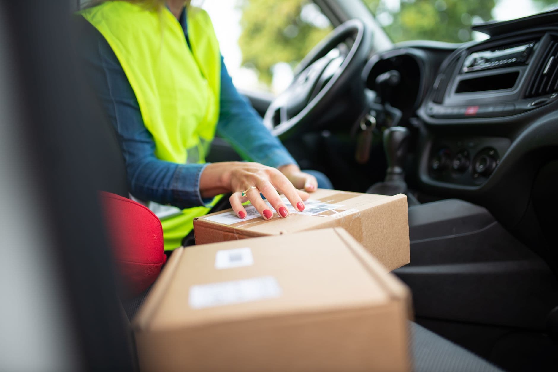 Parcels stacked in the back of a car with the hatch open on a suburban street