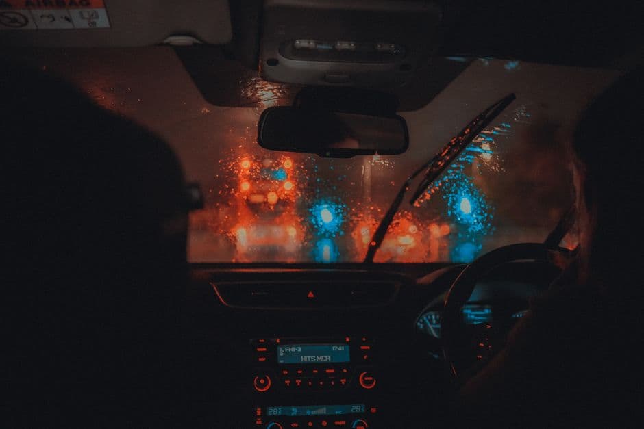 Heavy rain on a windshield with the road ahead blurred