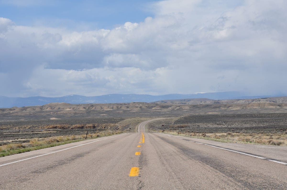 An empty highway stretching toward the horizon under a wide sky