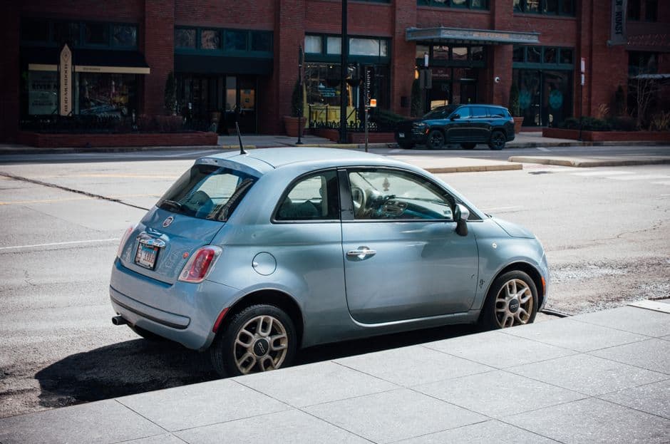 A small hatchback parked on a narrow street