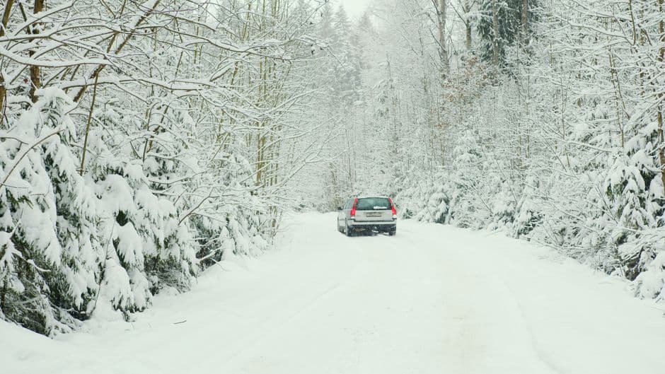 A car parked on a snow-covered road in winter