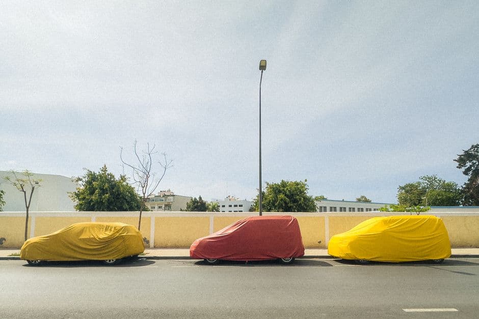 A car parked outdoors under a fitted protective cover
