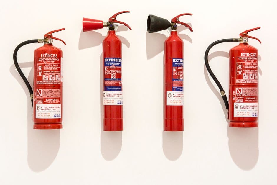 A small red fire extinguisher mounted in a vehicle