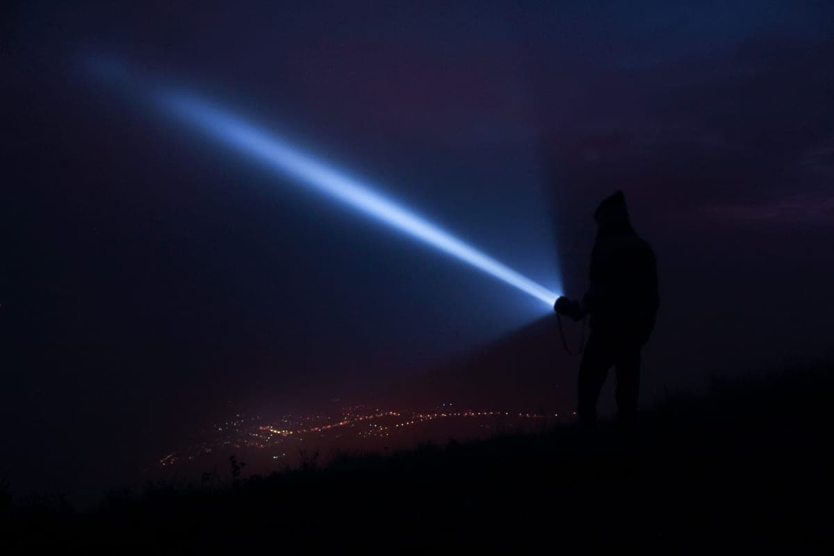 A flashlight beam cutting through darkness