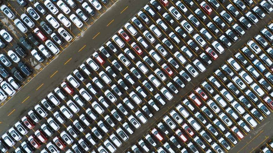 A parking area with rows of cars viewed from above