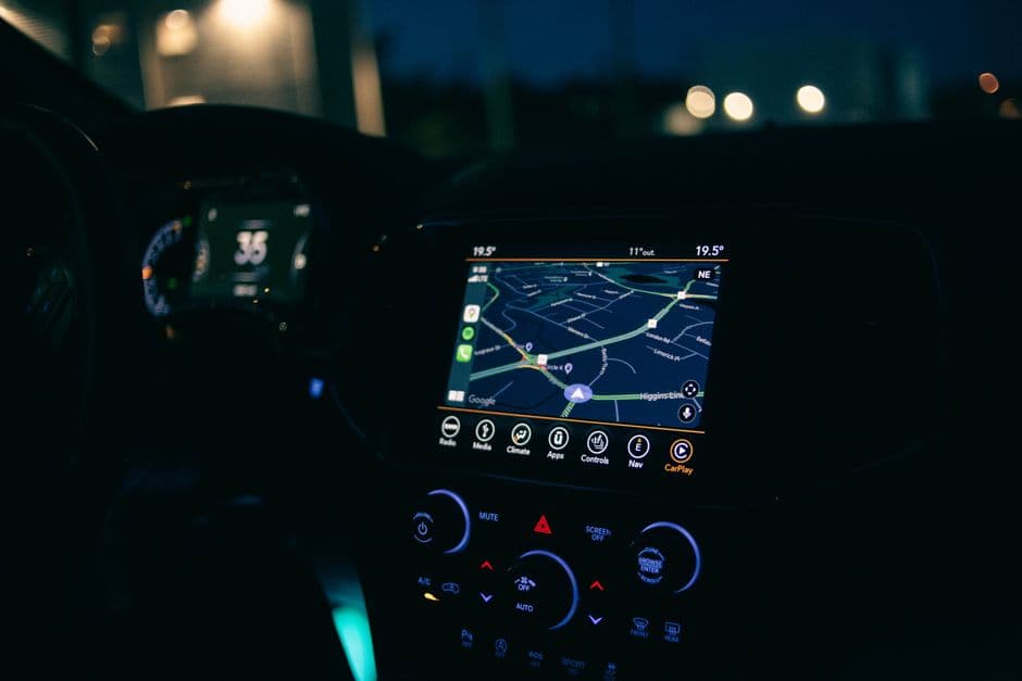 A navigation display glowing on a car dashboard at dusk