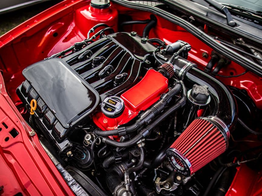 An engine air filter in its housing under a car hood