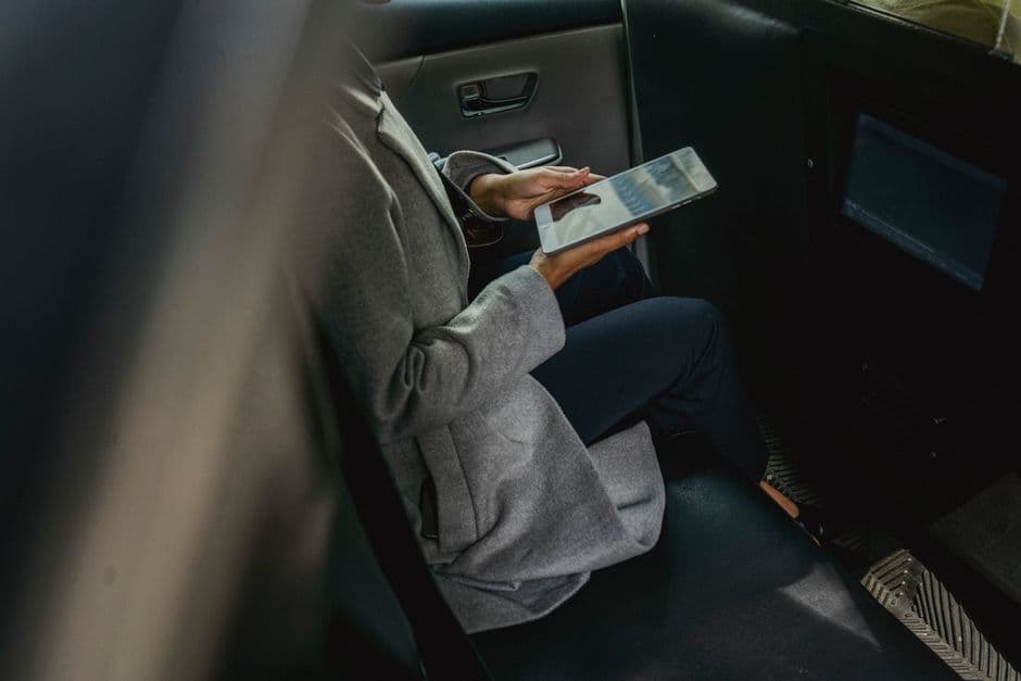 A tablet mounted on the back of a car headrest