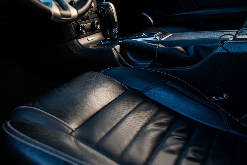 The stitched leather surface of a car seat in close detail