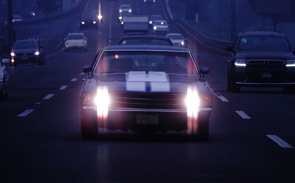 Car headlights illuminated on a dark road
