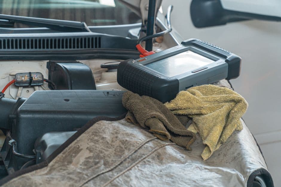 A diagnostic scan tool connected under a car dashboard