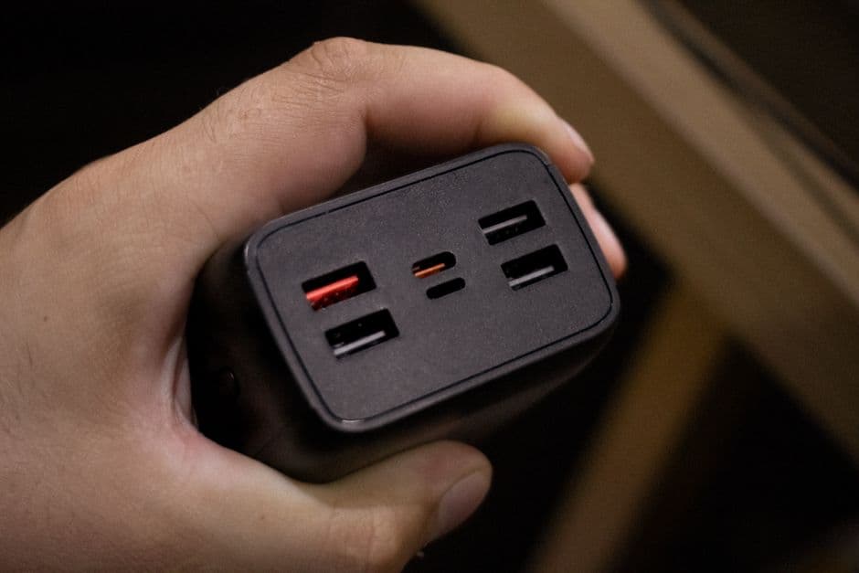 A portable battery pack on a table beside a phone