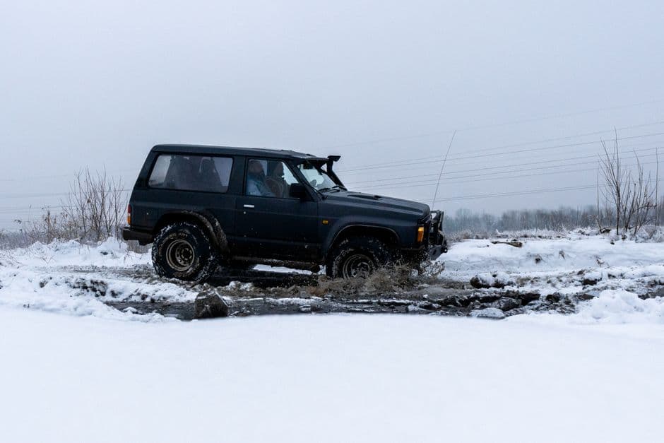 A car wheel stuck in deep snow at the roadside