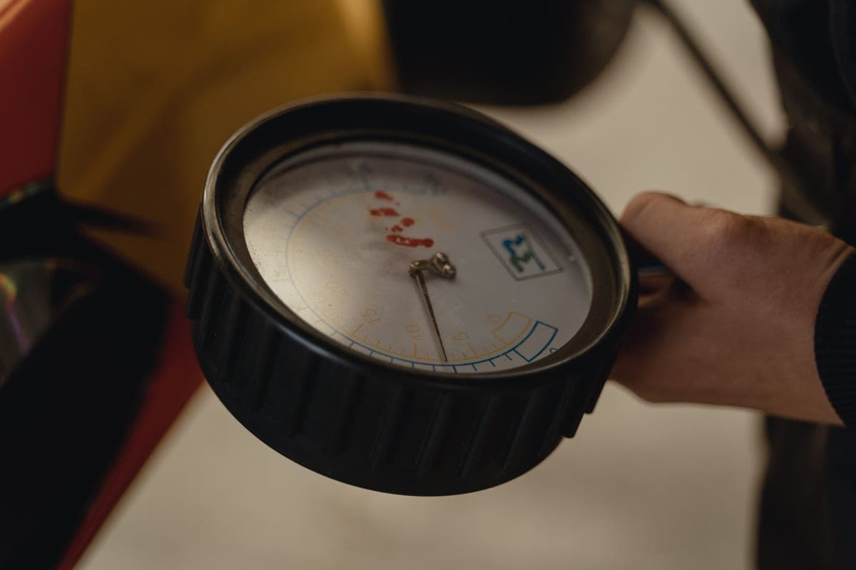 A digital pressure gauge held in a hand