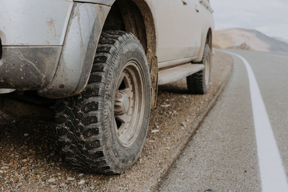 A car tire and wheel photographed at the roadside