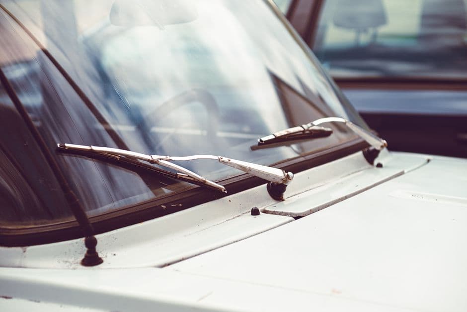 Rain on a car windshield with a wiper blade in view