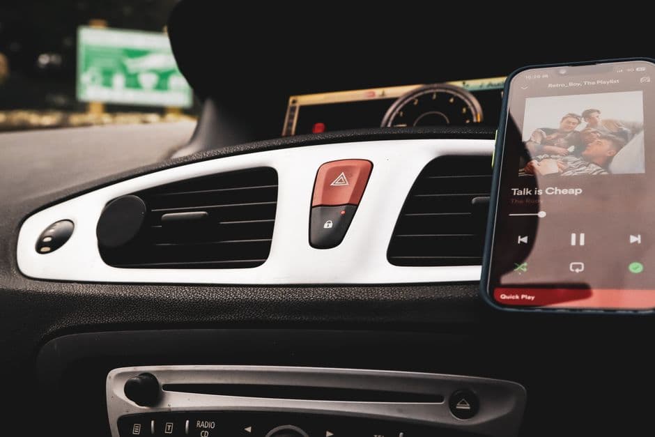 A phone resting on a mount attached to a car air vent