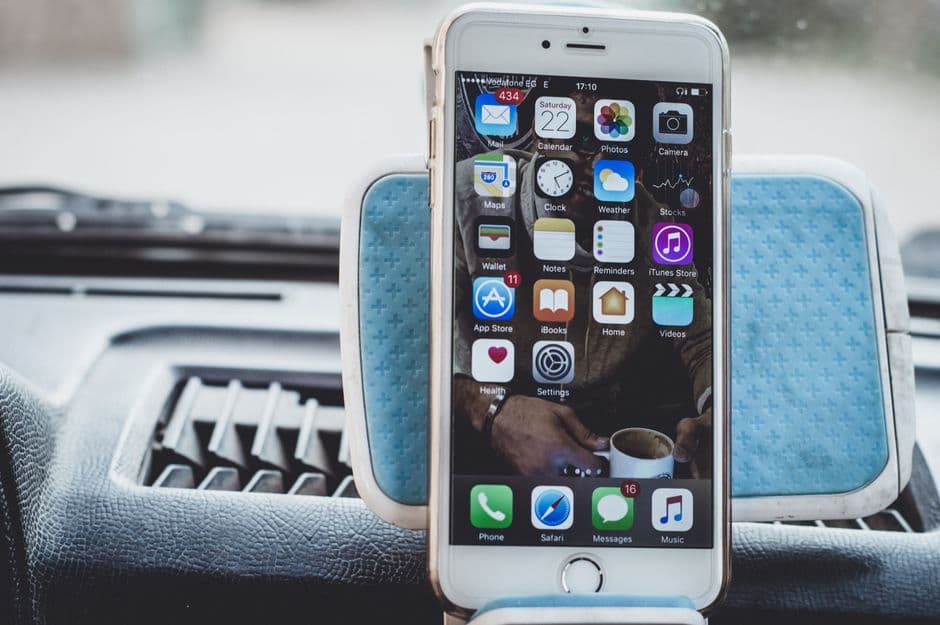 A smartphone held in a clamp mount inside a car