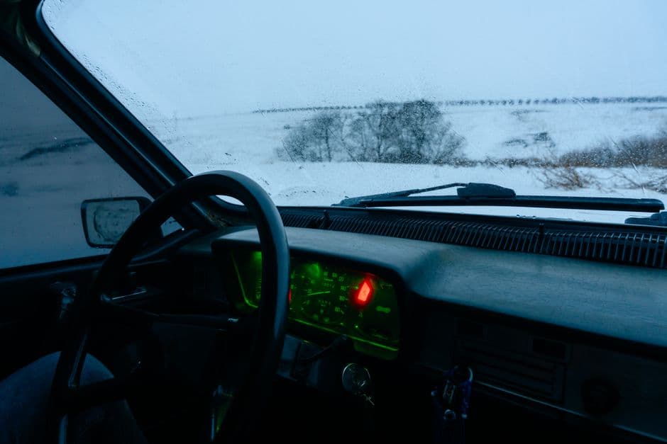 A frosted car interior on a cold morning with the steering wheel in view
