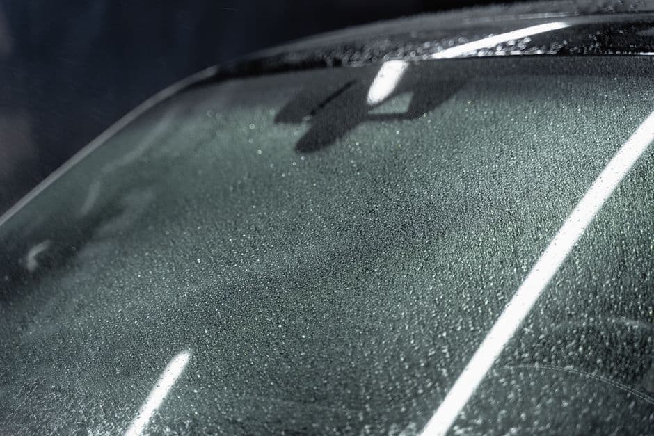 A fogged car windshield with condensation on the inside