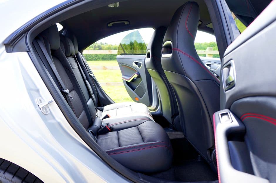 A car interior with the door open and light falling across the seats