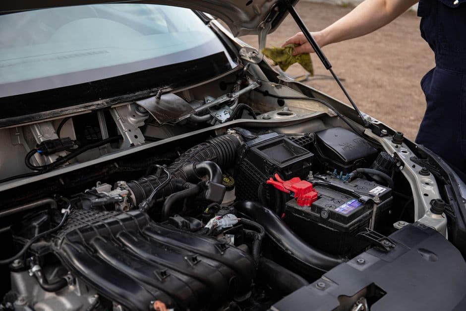 An open car hood showing the engine bay and battery