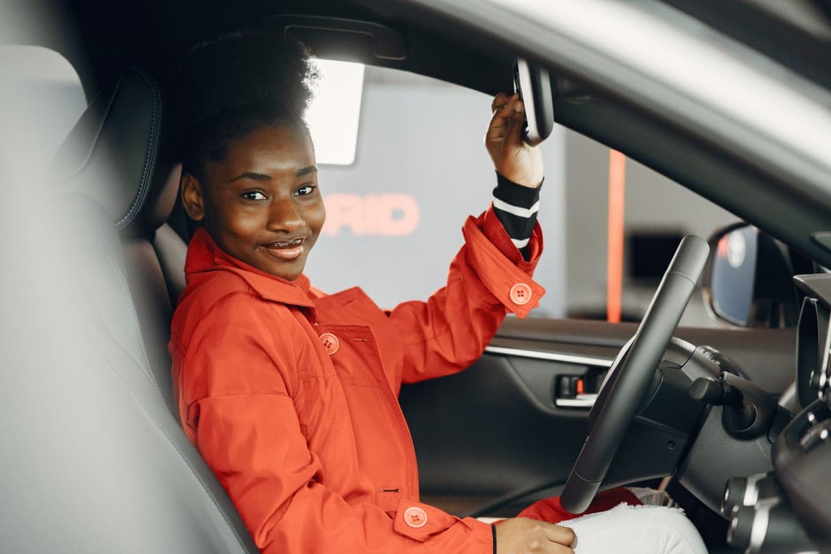 A driver adjusting the seat position inside a car