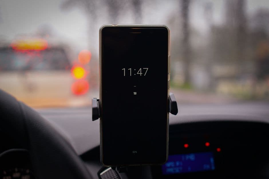 A phone held in a mount attached to a car dashboard