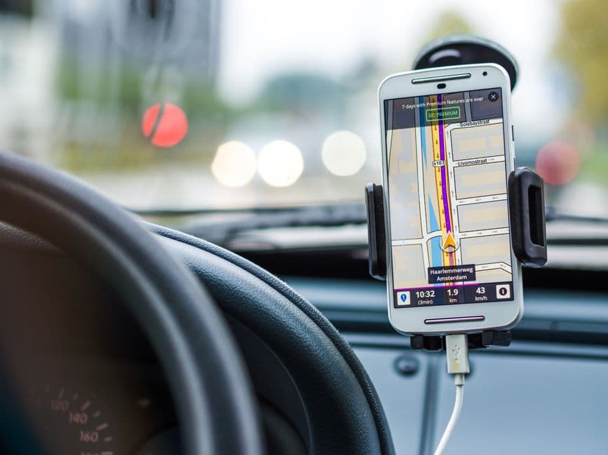 A smartphone attached to a mount in a car interior