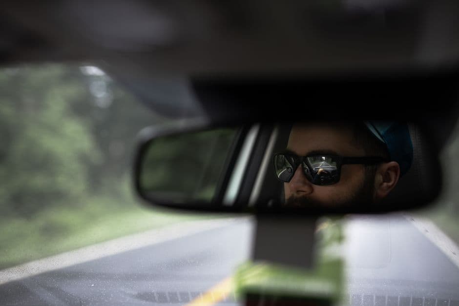 A dash cam mounted behind a car's rear-view mirror