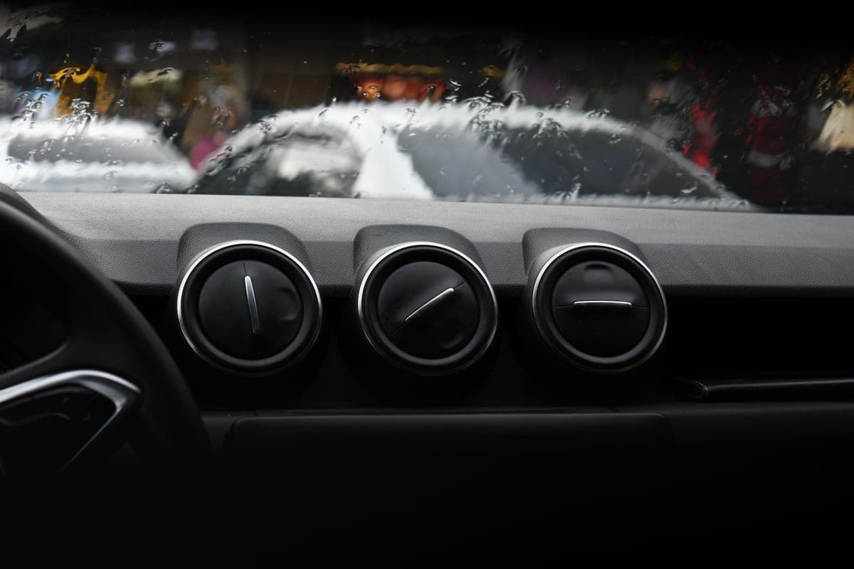 A car interior seen from the driver's seat showing the windshield, dashboard and vents