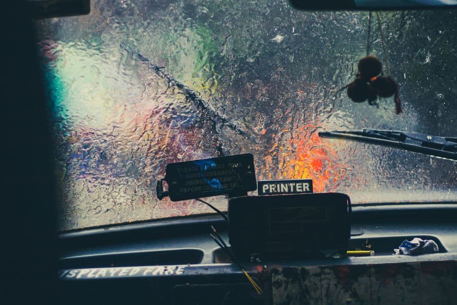 A compact dash cam mounted behind a car's rear view mirror