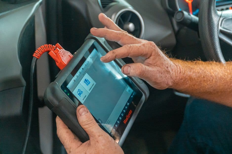 Hands working inside a car interior near the dashboard