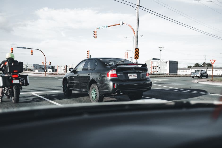 A car stopped on a road shoulder with hazard lights on