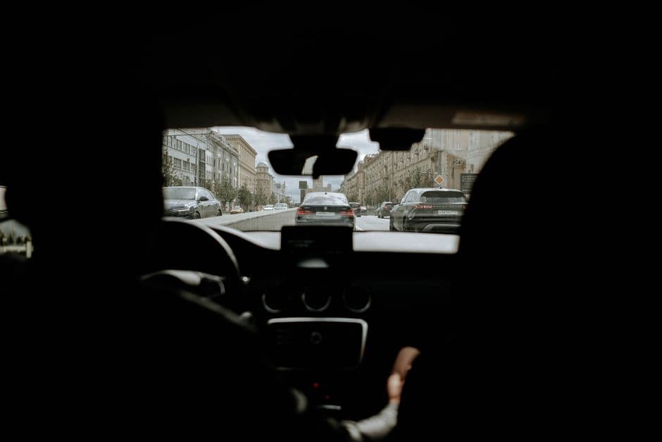 A driver's view through a windshield with the dashboard in frame