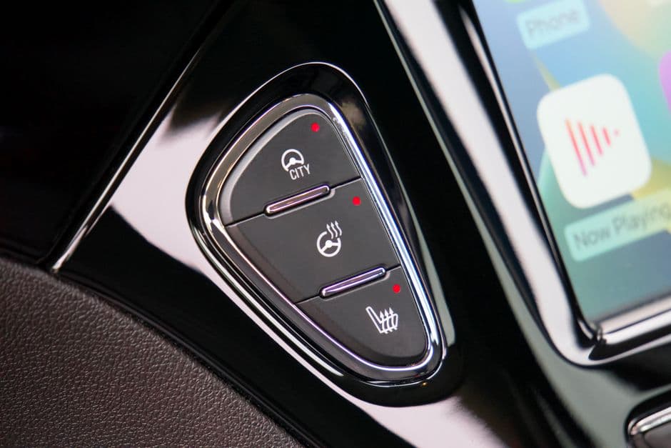 A phone on a car seat with a stereo display in the background