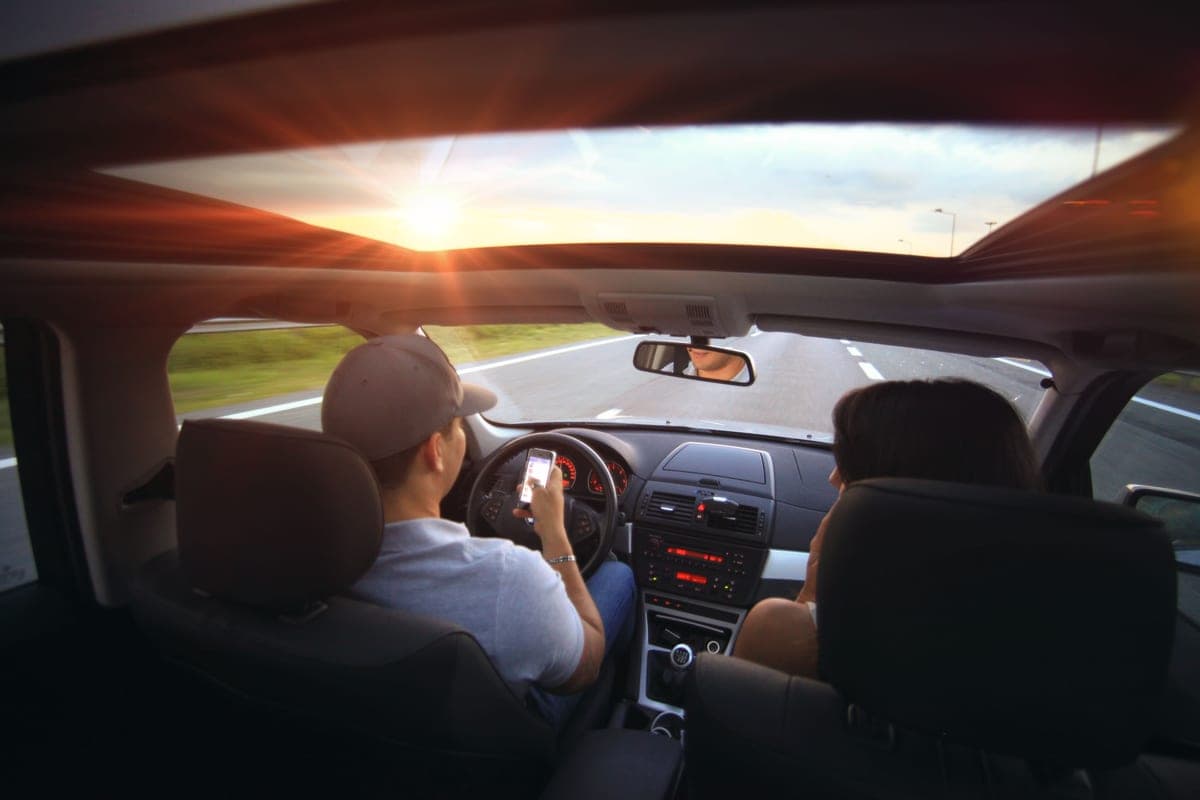 A driver using a car's central touchscreen while the vehicle is parked