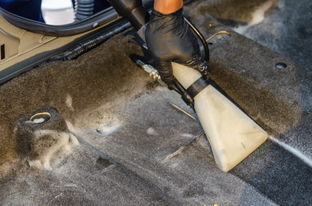 The carpeted footwell and door sill of a car interior