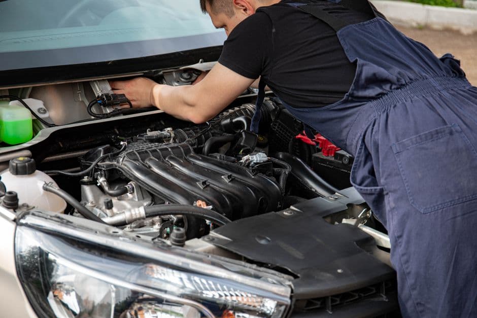 An open car hood with the engine bay visible in daylight